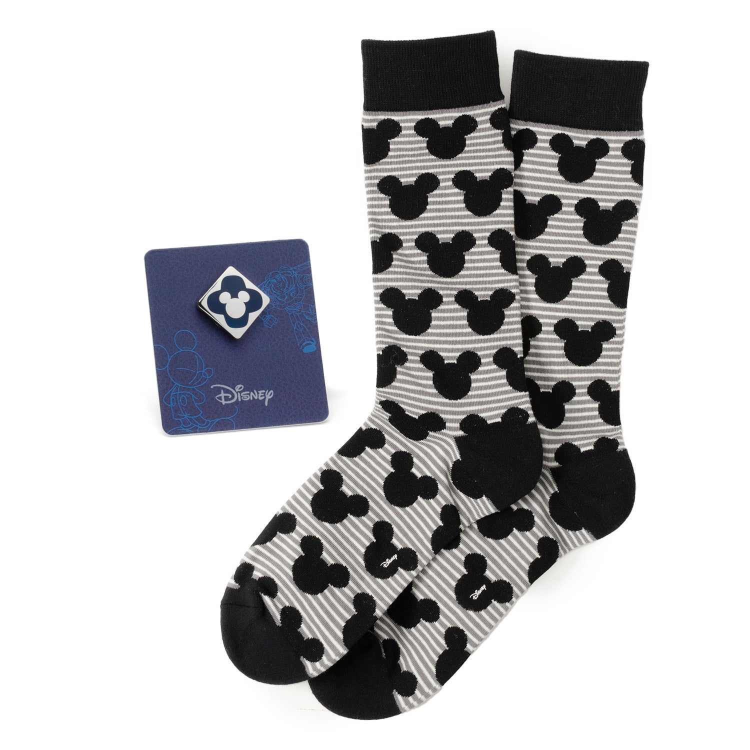 Celebrate Disney style with the Mickey Stripe Gray Sock and Mickey Blue Lapel Pin Gift Set. Featuring premium gray socks adorned with a stylish Mickey Mouse stripe pattern and a sophisticated enamel lapel pin in a striking blue hue showcasing Mickey Mouse, this set seamlessly blends whimsy and elegance. The socks, crafted from a soft, breathable cotton blend, offer comfort and durability, while the meticulously designed pin adds a distinctive touch to any outfit. Image 1