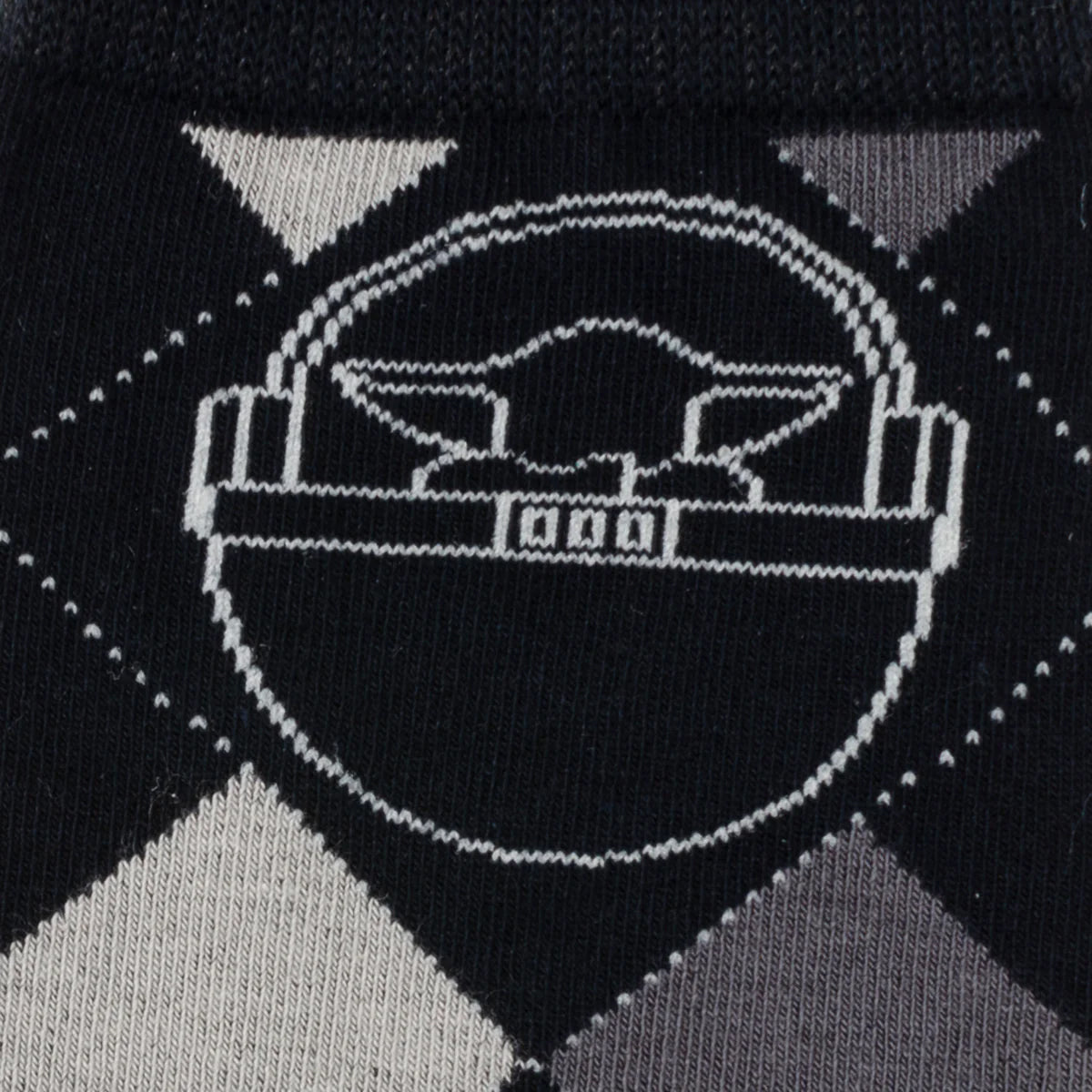 Embrace the charm of the galaxy's favorite foundling with the Grogu Argyle Charcoal Gift Set. This delightful set includes a pair of charcoal argyle socks featuring an adorable image of Grogu and a matching lapel pin. Perfect for the Star Wars fan who adores "The Mandalorian," these accessories blend classic style with whimsical appeal. Showcase your love for Grogu with every step and detail. Image 3